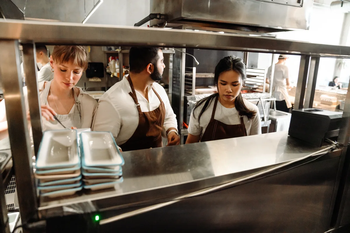 A restaurant operator at the kitchen pass during a busy service, the kind of moment AI tools cannot see