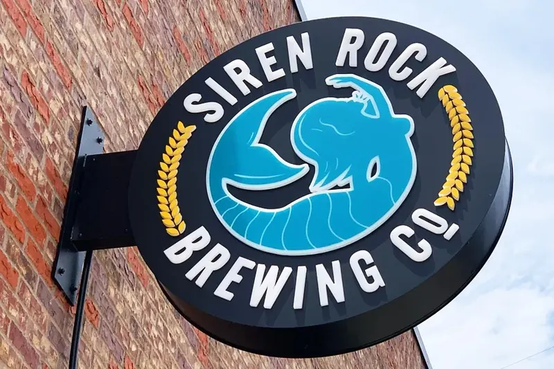 A projecting blade sign mounted on a brick facade