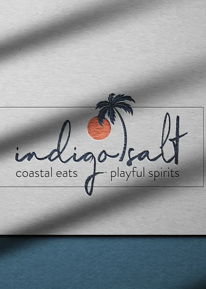 A coastal restaurant wordmark pressed into paper in raking light